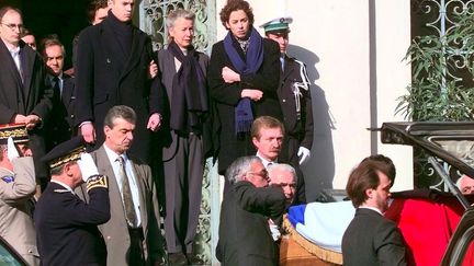 Le cercueil de Claude Erignac quitte la préfecture d'Ajaccio, le 8 février 1998, sous les yeux de Dominique Erignac et de ses enfants, Charles-Antoine et Marie-Christophine. (GEORGES GOBET / AFP)