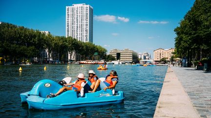 Des personnes font du pédalo sur le bassin de la Villette dans le cadre de Paris Plages le 2 août 2018. (MARIE MAGNIN / HANS LUCAS)