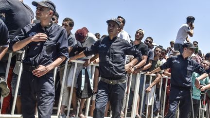 De jeunes Algériens font la queue devant un stade, le 16 juillet 2019, pour acheter des billets d'avion pour Le Caire afin de soutenir leur équipe lors de la finale de la CAN 2019, le 19 juillet, entre l'Algérie et le Sénégal. (RYAD KRAMDI / AFP)