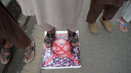 Des militants d'un parti islamiste marchent sur une photo d'Asia Bibi, dans une manifestation contre sa libération, à Islamabad (Pakistan), le 2 novembre 2018. (AAMIR QURESHI / AFP)