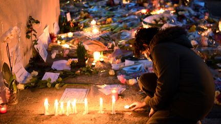 Un adolescent allume une bougie en hommage à Samuel Paty, enseignant assassiné à Conflans-Sainte-Honorine, le 17 octobre 2020. (BERTRAND GUAY / AFP)