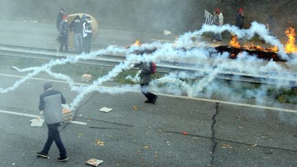 Des manifestants vis&eacute;s par des gaz lacrymog&egrave;nes, le 26 octobre 2013, &agrave; Pont-de-Buis, dans le Finist&egrave;re. (FRED TANNEAU / AFP)