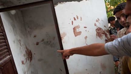 Des Syriens montrent le sang sur les murs d'une maison de Treimsa, o&ugrave; 150 personnes ont &eacute;t&eacute; tu&eacute;es le 13 juillet 2012, selon&nbsp;l'Observatoire syrien des droits de l'Homme. (D. LEAL OLIVAS / AFP)