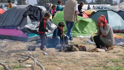 Des enfants tentent de se réchauffer dans le camp grec d'Idomeni qui compte 13 000 migrants, le 7 mars 2016. (BESAR ADEMI / ANADOLU AGENCY)