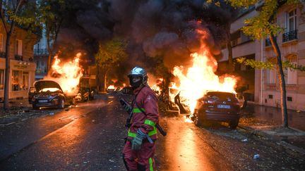 Un pompier intervient près de voitures qui brûlent à Paris, le 1er décembre 2018. (ALAIN JOCARD / AFP)