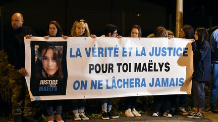 Des gens tiennent une banderole, alors qu'un convoi de véhicules de police français transportant Nordahl Lelandais quittait Pont-de-Beauvoisin, le 24 septembre 2018. (JEAN-PHILIPPE KSIAZEK / AFP)