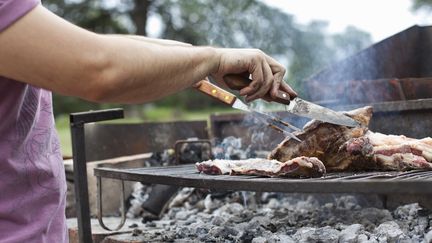 Un homme prépare un barbecue, le 23 mars 2015. (KATHRIN ZIEGLER / TAXI / GETTY IMAGES)