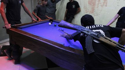 Des combattants de l'arm&eacute;e syrienne libre jouent au billard &agrave; Alep (Syrie), le 9 septembre 2013. (REUTERS)