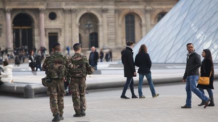 Des militaires patrouillent autour de la pyramide du Louvre, à Paris, le 3 décembre 2015. (OLIVIER BOITET / MAXPPP)