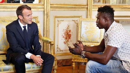 Le président de la République, Emmanuel Macron et Mamoudou Gassama, jeune Malien sans-papiers qui a sauvé un enfant, le 28 mai 2017 à l'Elysée.&nbsp; (THIBAULT CAMUS / AFP)