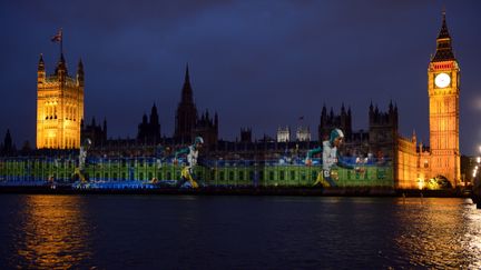 Pendant ce temps l&agrave;, au bord de la Tamise, la sprinteuse australienne Cathy Freeman&nbsp;s'invite &agrave; Westminster. En capuche. (ERIC FEFERBERG / AFP)