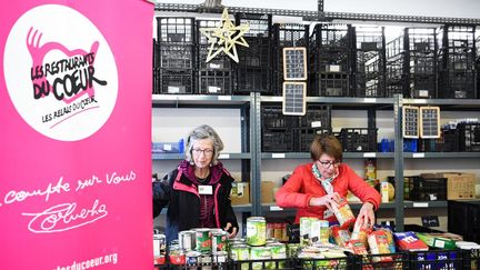 Des volontaires préparent les étals d'un centre des restos du cœur. (BERTRAND GUAY / AFP)