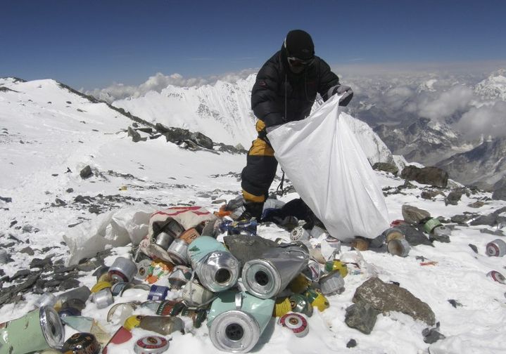 Un sherpa ramasse des d&eacute;chets sur le mont Everest, le 23 mai 2010.&nbsp; (NAMGYAL SHERPA / AFP)