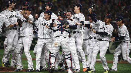 Les joueurs japonais fêtent leur victoire contre la Corée du Sud, le 17 novembre 2019 au Tokyo Dome. (CHARLY TRIBALLEAU / AFP)