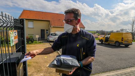 Les facteurs continuent leurs tournées en période de confinement pour assurer la distribution du courrier. Ci-contre dans l'Aube, le 18 mars 2020. (PASCAL BROCARD / MAXPPP)