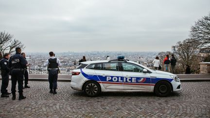 Une voiture de police et des policiers à Paris le 17 mars 2020. (MATHIEU MENARD / HANS LUCAS / AFP)