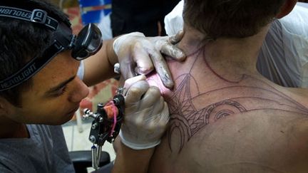 Le tatoueur Luther Berg en pleine action dans son studio à Avoura, capitale des Cook sur l'île de Rarotonga (29 août 2012). (AFP PHOTO / Marty Melville)