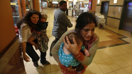 Une femme porte son enfant dans le centre commercial&nbsp;"Westgate Mall", situ&eacute; &agrave; Nairobi (Kenya), et cible d'une attaque terroriste le 21 septembre 2013. (GORAN TOMASEVIC / REUTERS)