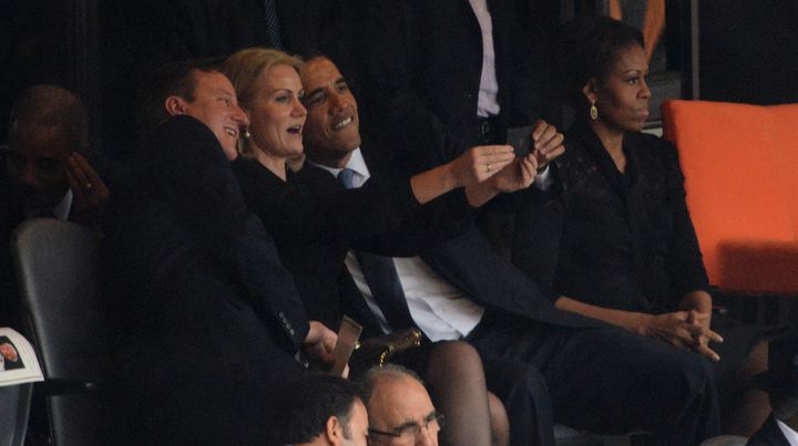 David Cameron, Helle Thorning-Schmidt et Barack Obama (de gauche &agrave; droite) se prennent en photo, &agrave; c&ocirc;t&eacute; de Michelle Obama, lors de l'hommage &agrave; Nelson Mandela, le 10 d&eacute;cembre 2013. (ROBERTO SCHMIDT / AFP)