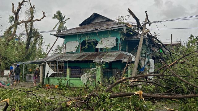 Wind-blown trees near a house in Kyauktaw, Burma, on May 14, 2023, after Cyclone Mocha hit.  (SAI AUNG MAIN / AFP)