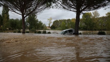 Une voiture prise dans une inondation à Trèbes (Aude), le 14 octobre 2018. (ALINE LAFOY / AFP)