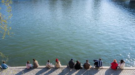 Des Parisiens prennent le soleil en bord de Seine, le 20 mars 2021. (SANDRINE MARTY / HANS LUCAS / AFP)