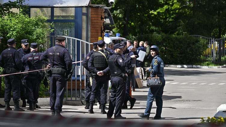 Des agents des forces de sécurité près d'un bâtiment endommagé par une attaque de drones à Moscou (Russie), le 30 mai 2023. (SEFA KARACAN / ANADOLU AGENCY / AFP)