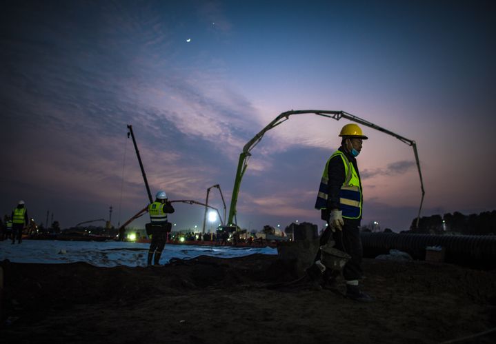 Des ouvriers s'afférant sur le site de chantier de construction de l'hôpital de&nbsp;Huoshenshan, à Wuhan, le 28 janvier 2020.&nbsp; (XIAO YIJIU / XINHUA / AFP)