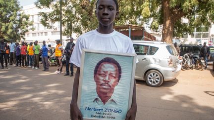 13 décembre 2018, Ouagadougou, Burkina Faso. 20e anniversaire de l'assassinat du journaliste reporter indépendant, Norbert Zongo. Un homme tient le portrait de Norbert Zongo, tandis que des milliers de personnnes manifestent  en ce 13 décembre 2018. (Ilustration) (OLYMPIA DE MAISMONT / AFP)