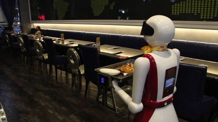 Le robot, qui mesure 1,60 m de haut et est rechargé une fois par jour (pendant quatre heures), apporte lui-même leurs commandes aux clients de ce restaurant. Dont l’ambiance n’est pas sans évoquer celle des peintures de l’artiste américain Edward Hopper... Le personnel humain place un plat sur le plateau de la machine et indique la table à livrer par le biais d’une télécommande. L’initiative de Binzhou n’est pas la première du genre en Chine. A Harbin (nord-ouest), un tel restaurant a ouvert ses portes en 2012. Là, le robot peut préparer des nems, servir les clients, débarrasser les tables, faire la vaisselle. Le directeur de l’établissement explique que ces machines sont moins exigeantes que les humains. Et ne rechignent pas à travailler le dimanche.  (SIPA ASIA - SIPA)