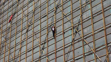 Une femme menace de se jeter d'un &eacute;chaffaudage sur un immeuble en construction &ccedil; Wenzhou (Chine), le 5 novembre 2013. Son &eacute;poux, dont elle tient ici le portrait est mort sur ce m&ecirc;me site de fa&ccedil;on inexpliqu&eacute;e. (REUTERS)