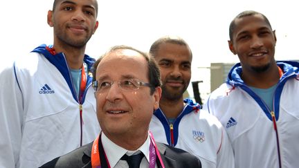 Fran&ccedil;ois Hollande avec les basketeurs de l'&eacute;quipe de France,&nbsp;Tony Parker, Nicolas Batum et Boris Diaw lors de sa visite &agrave; Londres, le 30 juillet 2012 aux JO de Londres.&nbsp; (GABRIEL BOUYS / POOL)