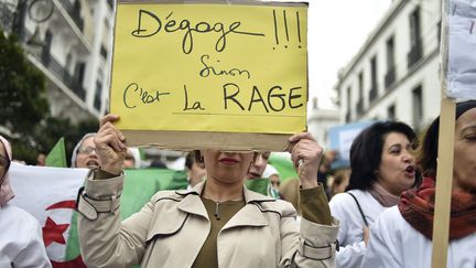 19 mars 2019. Une manifestante brandit un panneau pour dénoncer le maintien au pouvoir du président Bouteflika. (RYAD KRAMDI / AFP)