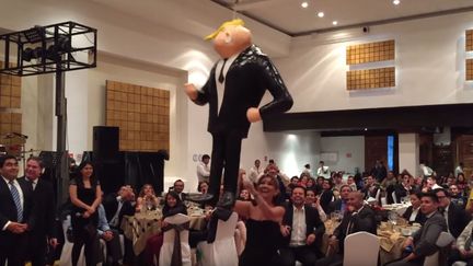 &nbsp;Des sénateurs frappent une piñata à l'effigie de Donald Trump lors d'un dîner de Noël. (EL PODER TV / YOUTUBE)