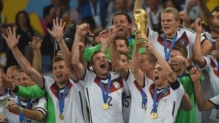 La Mannschaft remporte la Coupe du monde et le&nbsp;capitaine allemand Philipp Lahm soul&egrave;ve le troph&eacute;e entour&eacute; de ses co&eacute;quipiers, dimanche 13 juillet, &agrave; Rio (Br&eacute;sil). (PATRIK STOLLARZ / AFP)