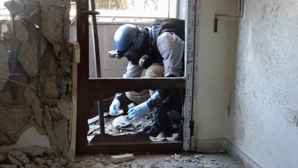 Un expert de l'ONU relevant des &eacute;chantillons dans la banlieue de Damas (Syrie), th&eacute;&acirc;tre d'une possible attaque chimique du r&eacute;gime syrien, le 29 ao&ucirc;t 2013. (AMMAR AL-ARBINI / AFP)