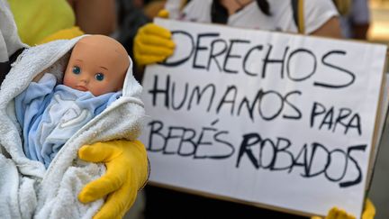 Pancarte avec le slogan "Droits humains pour les bébés volés" lors d'une manifestation à l'ouverture du procès du docteur Eduardo Vela à Madrid, le 26 juin 2018. (OSCAR DEL POZO / AFP)