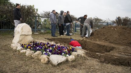 Des hommes creusent la tombe d'Ariel Sharon, dimanche, &agrave; Havat Hashikmim, dans le sud d'Isra&euml;l, o&ugrave; sa femme est enterr&eacute;e et o&ugrave; le couple poss&eacute;dait une r&eacute;sidence. L'inhumation aura lieu lundi apr&egrave;s-midi. (ILIA YEFIMOVICH / GETTY IMAGES)