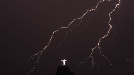 Des &eacute;clairs illuminent la statue du Christ R&eacute;dempteur &agrave; Rio de Janeiro (Br&eacute;sil), le 14 janvier 2014. (YASUYOSHI CHIBA / AFP)