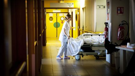 Une infirmière travaillant de nuit dans un hôpital d'Aulnay-sous-Bois (Seine-Saint-Denis) pousse un patient, le 14 novembre 2012. (AMELIE BENOIST / AFP)