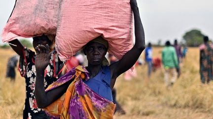 Des villageoises récupèrent des aides du&nbsp;Programme&nbsp;alimentaire mondial, le 6 février 2020, dans le village d'Ayod (Soudan du Sud). (TONY KARUMBA / AFP)