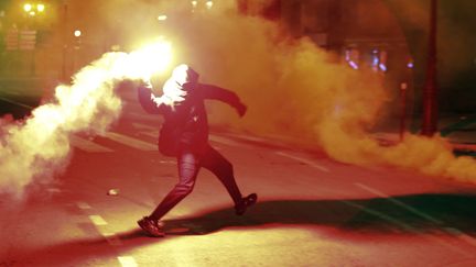 Un manifestant tient un cocktail molotov à la main, devant la préfecture d'Ajaccio (Corse-du-Sud), le 9 mars 2022. (PASCAL POCHARD-CASABIANCA / AFP)