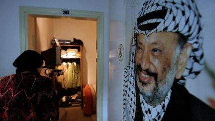 Dans le musée Arafat à Ramallah, le 9 novembre 2016, un visiteur regarde des effets personnels du leader palestinien avec, à droite, l'un de ses portraits. (REUTERS - Mohamad Torokman)