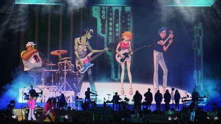 Le groupe Gorillaz de Damon Albarn (au micro en rose à droite) et les quatre personnages animés de Jamie Hewlett qui en constituent les musiciens "virtuels", jeudi 2 juin 2022 au festival We Love Green. (SADAKA EDMOND/SIPA)