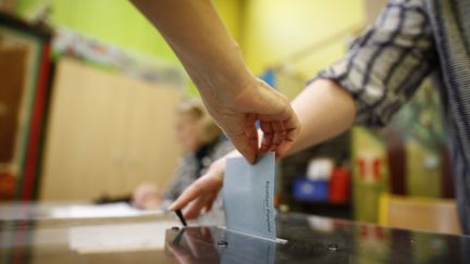 Un homme dépose son bulletin de vote dans l'urne lors des élections législatives, en juin 2018.&nbsp; (BENJAMIN CREMEL / AFP)