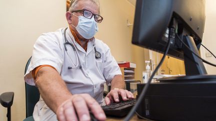 Un médecin généraliste dans son cabinet portant un masque de protection. Illustration. (VINCENT ISORE / MAXPPP)