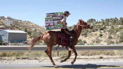 Un mara&icirc;cher transporte &agrave; cheval des cageots de fruits pr&egrave;s d'H&eacute;bron (Palestine), le 15 juin 2014. (MENAHEM KAHANA / AFP)