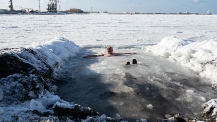 Un fidèle orthodoxe dans l'eau glacée à&nbsp;Kholmsk, en Russie, pour célébrer l'Epiphanie, le 19 janvier 2019. (SERGEI KRASNOUKHOV / AFP)