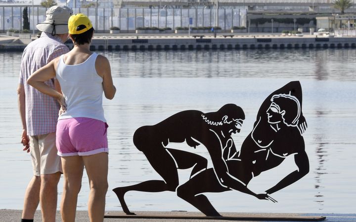 Des passants devant une sculpture d'un couple signée Antoni Miro, à Valence.
 (Jose Jordan / AFP)