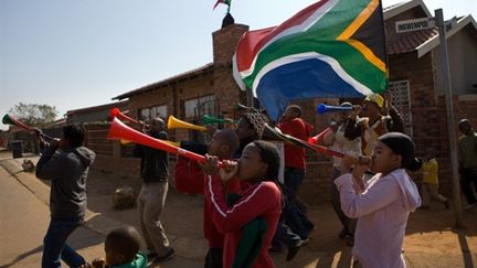 Des jeunes habitants de Soweto en train de souffler dans leurs vuvuzelas, la veille du coup d'envoi du Mondial (AFP - Yasuyoshi Chiba)